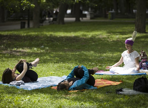 image of person sitting in yogic position with two other people doing stretches in front of them